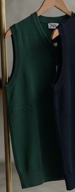Forest green knit V-neck vest on a hanger